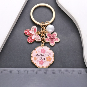 Porte-clés Fête des Mères avec papillon rose, fleur, perles et pendentif doré