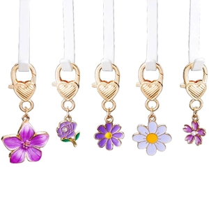 Detail of five purple enamel flower pendants with heart-patterned golden lobster clasps