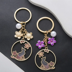 Porte-clés chat fleurs de cerisier doré avec fleurs en émail violet et perles