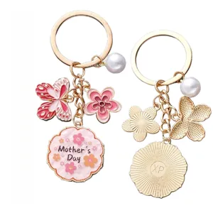 Détail du porte-clés papillon en émail rose avec perle et breloque fleur de fête des mères