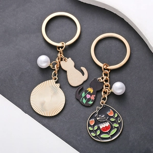 Porte-clés en alliage doré avec chat en émail noir, charme floral et fausse perle