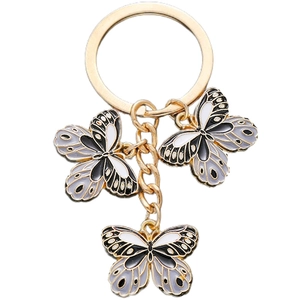 Detail eines goldenen Schmetterling-Schlüsselanhängers mit schwarz-weißer Emaille