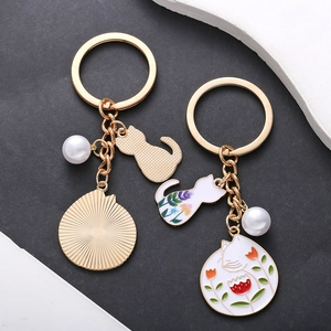 Set portachiavi gatto e fiori smaltati in finitura oro con ciondoli in perla bianca