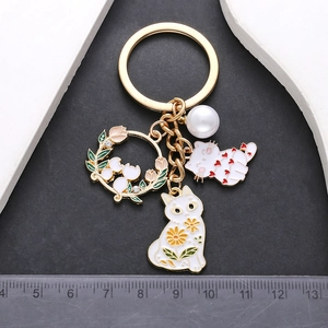 Golden cat keychain with white enamel floral cat charms and elegant pearl pendant