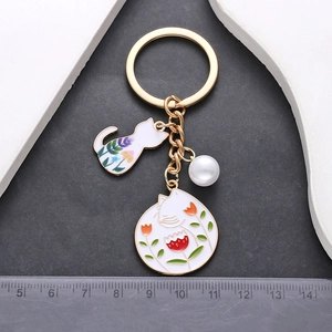 Portachiavi gatto bianco e fiori smaltati in lega dorata con perla sintetica di lusso