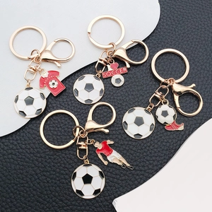 Detail of soccer keychain charms featuring enamel jersey and soccer player on gold alloy
