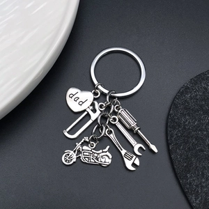 Porte-clés moto argenté avec cœur Dad et pendentifs outils sur un fond de décor sombre