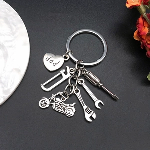 Gros plan du porte-clés argenté pour papa avec pendentifs d'outils et cœur gravé
