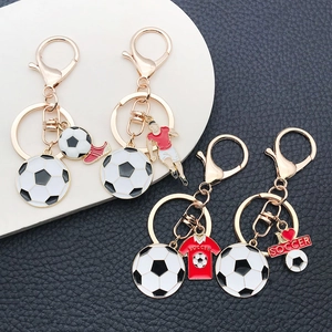 Macro detail of gold-tone soccer keychain set with colorful enamel charms on leather