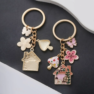 Pink mushroom house keychain with flower and butterfly charms in light gold alloy