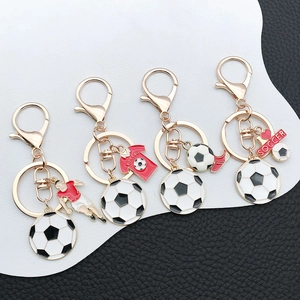 Detailed macro view of soccer keychain featuring golden football, jersey and shoe charms
