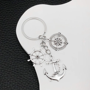 Silver nautical keychain featuring a detailed compass, ship wheel, and anchor charms