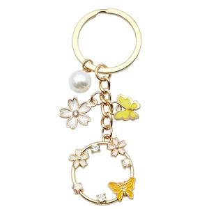 Golden butterfly and pearl keychain with yellow floral enamel and sparkling rhinestones