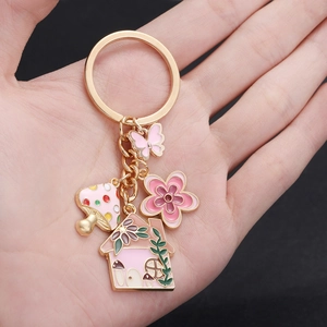 Pink enamel keychain with mushroom house flower and butterfly on golden ring