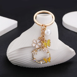 Golden butterfly and pearl keychain with white cherry blossom charms for handbags