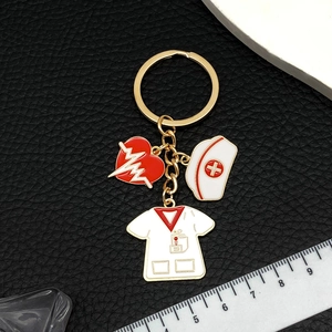 Medical themed keychain with nurse hat and stethoscope heart pendants in gold finish