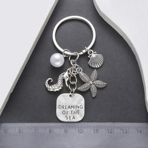 Vue détaillée du porte-clés marin argenté avec pendentifs hippocampe, étoile de mer et perle