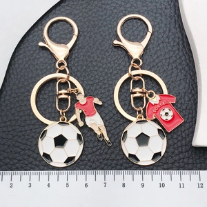 Close-up of a miniature soccer keychain on a black background with a measuring ruler