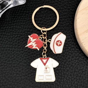 Golden medical keychain with heart, nurse hat and doctor outfit enamel pendants