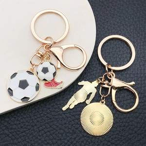 Detail of soccer themed keychains with enamel football and miniature sports shoe charms