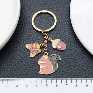 Golden squirrel and pumpkin carriage keychain with enamel charms on black leather