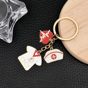 Detail of medical heart and nurse hat enamel charms on a golden metal keychain