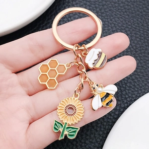 Enameled sunflower bee honeycomb keychain with rose gold plating and pearl accents