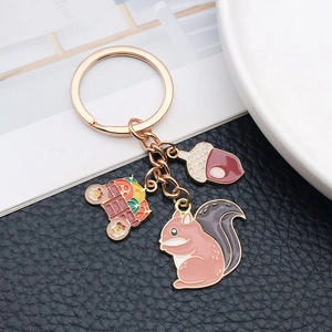 Golden harvest keychain with enamel squirrel, acorn and fruit cart charms on a leather base