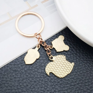Close-up of golden metal squirrel and acorn charms on a premium keychain pendant