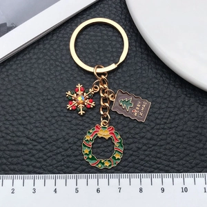 Porte-clés de Noël avec flocon doré, couronne festive et étiquette Merry X-mas sur cuir noir