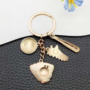 Detailed close-up of golden metal baseball theme keychain with glove and bat charms