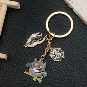 Détail d'un porte-clés d'Halloween avec breloques de lune noire et toile d'araignée dorée