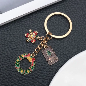 Porte-clés de Noël détaillé avec flocon doré, couronne festive et étiquette gravée