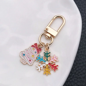 Close-up of pink Christmas tree and colorful snowflake keychain with golden plating detail
