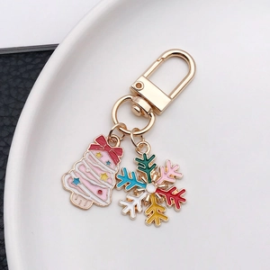 Close-up of pink enamel Christmas tree and colorful snowflake charms on a golden keychain