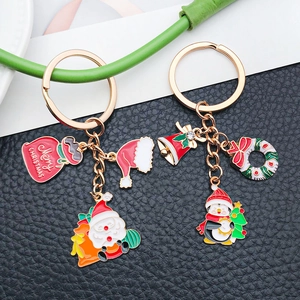 Detail of Christmas keychains with Santa and penguin enamel pendants on gold alloy