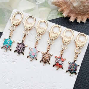 Detail of six turtle charms with colorful floral patterns and heart-shaped lobster clasps