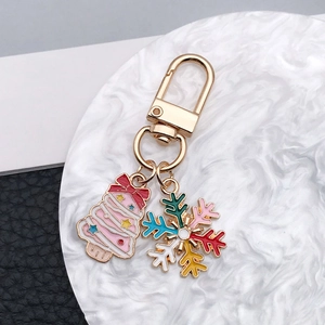 Detail of Christmas tree and colorful snowflake charms on a golden metal keychain