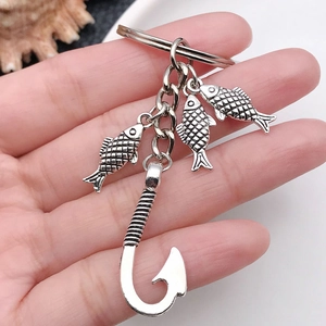 Antique silver keychain featuring three textured fish pendants and a large fishing hook charm