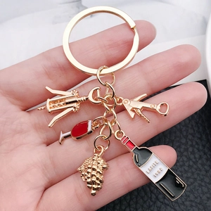 Gold wine themed keychain featuring bottle opener, grapes and red wine glass charms