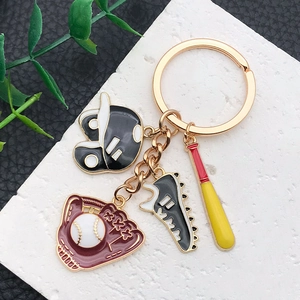 Baseball themed keychain with mini glove helmet and sneaker charms on stone background