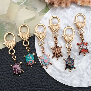 Set of six colorful turtle pendants with floral patterns and golden heart lobster clasps