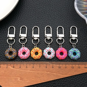 Vue détaillée de 6 porte-clés beignets en acrylique coloré avec décors de vermicelles