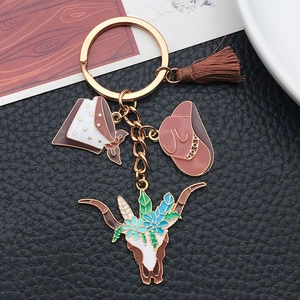 Detail of western cowboy hat keychain with enamel bull skull, flowers and brown tassel