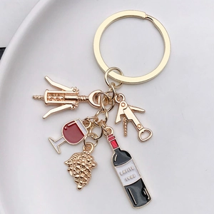 Macro view of KC gold wine theme keychain with corkscrew and Lafite bottle charms