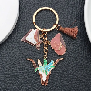 Detail of Western cowboy keychain with bull skull, hat, scarf, and brown tassel charms