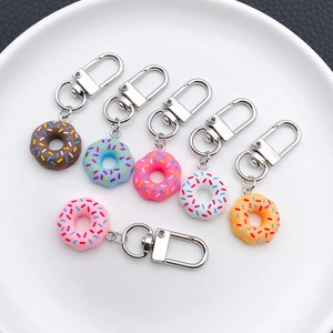Lot de six porte-clés donuts colorés dans un plat blanc sur fond de cuir noir élégant