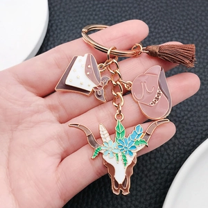 Western cowboy keychain featuring pink hat, longhorn skull, and brown tassel pendant