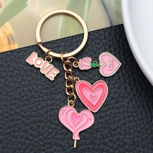 Detail of pink heart and rose pendants with LOVE charm on a gold keychain