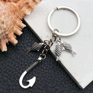 Detail of vintage silver fishing keychain with three small fish and a large hook pendant